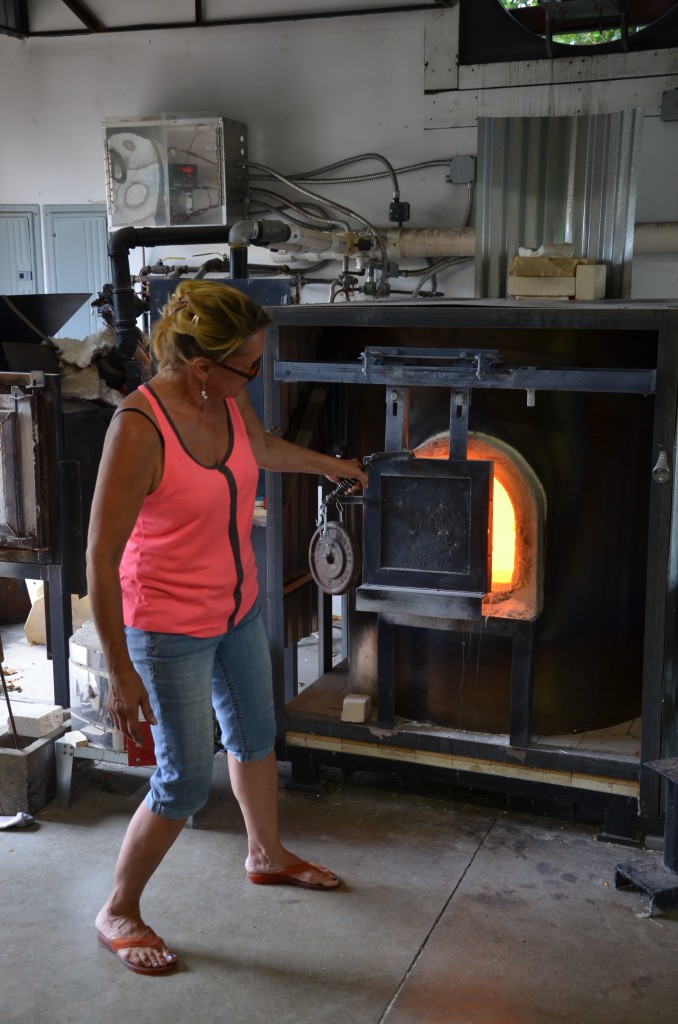 Opening up the oven to put in the raw glass.